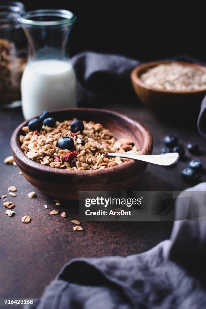 homemade crunchy granola in wooden bowl - granola stockfoto's en -beelden