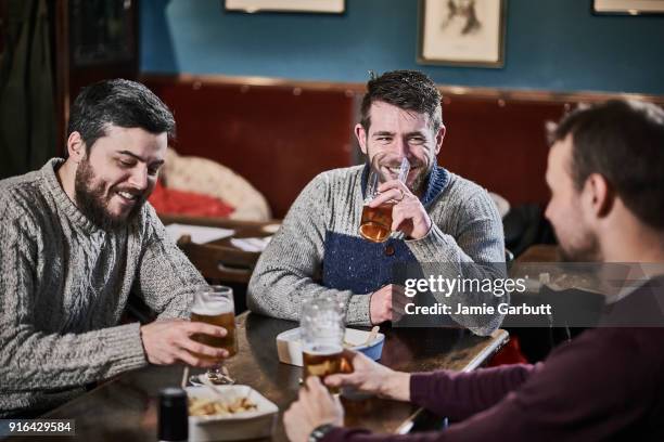 three friends sat in a british pub laughing together - pub food stock pictures, royalty-free photos & images