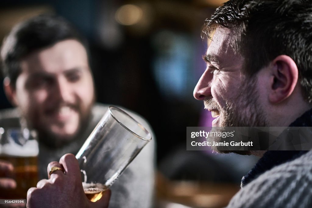 British males drinking a beer in a traditional pub