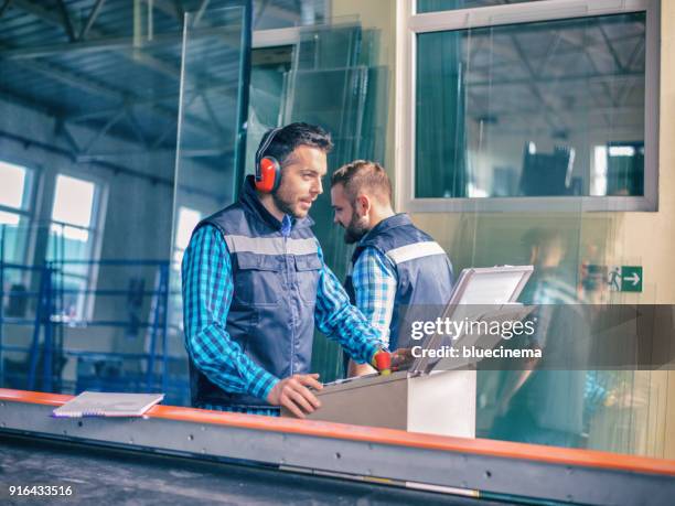 arbeiter in der fabrik - handhaben stock-fotos und bilder