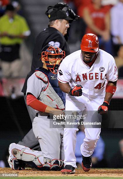 Torii Hunter of the Los Angeles Angels of Anaheim reacts to hitting a three-run home run as catcher Victor Martinez of the Boston Red Sox look on in...