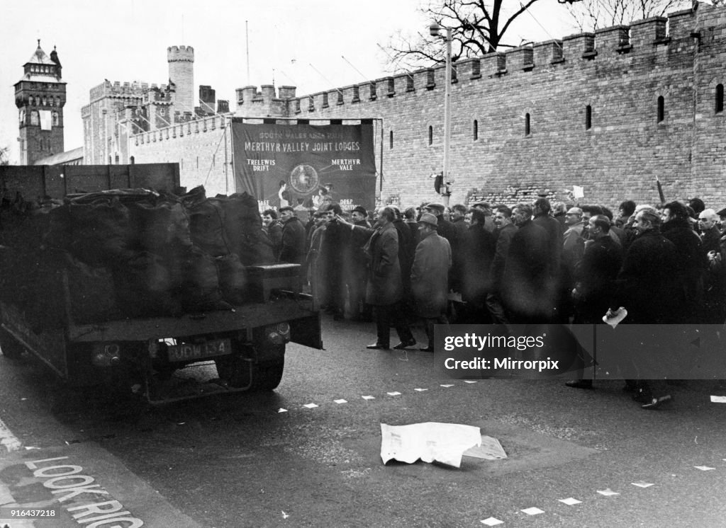 Minhers Miners Strike. A fully loaded coal lorry overtakes marching miners ...