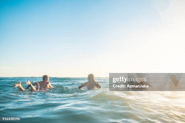 amigos preparándose para navegar en el océano - gold coast australia fotografías e imágenes de stock