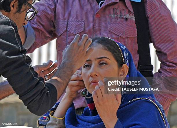 An assistant applies makeup on Bollywood actress Manisha Koirala on location during the filming of "Meghna" under tight security cover in Srinagar on...