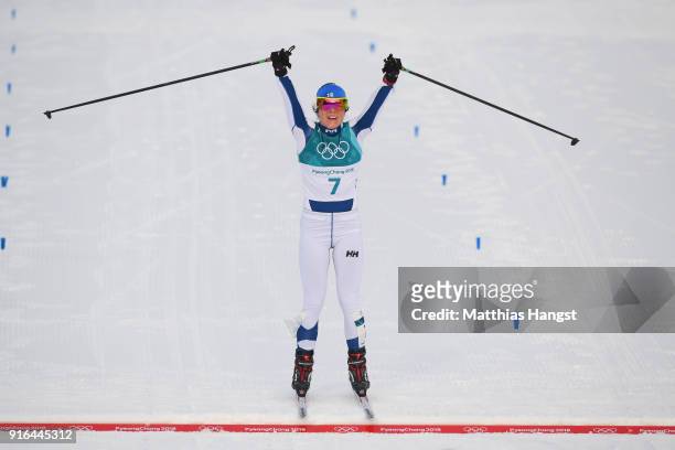 Krista Parmakoski of Finland celebrates crossing the finish line to win bronze during the Ladies Cross Country Skiing 7.5km + 7.5km Skiathlon on day...