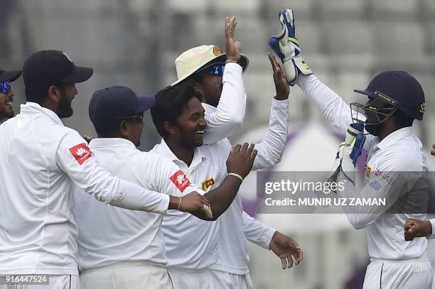 Sri Lanka cricketers congratulate teammate Akila Dananjaya after taking the wicket of the Bangladesh cricketer Mehidy Hasan during the third day of...