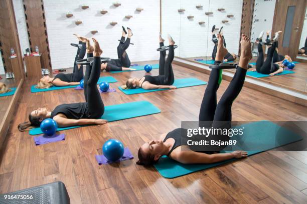 Group of sporty women working out with pilates rings in health club.