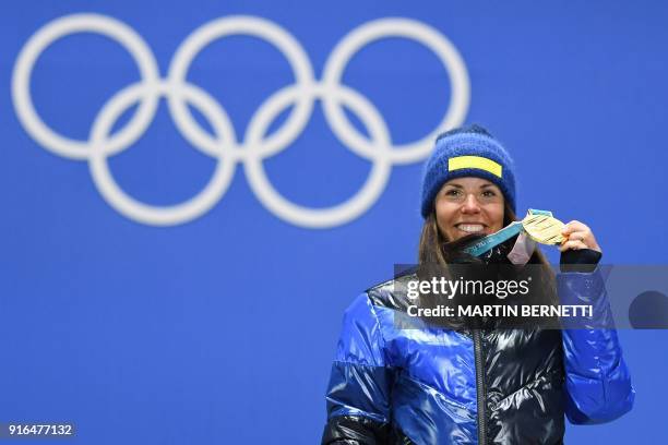 Sweden's Charlotte Kalla celebrates on the podium during the medal ceremony after taking first place in the women's 7.5km + 7.5km cross-country...