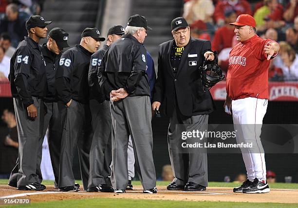 Mike Scioscia manager of the Los Angeles Angels of Anaheim speaks to the umpires at the start Game One of the ALDS against the Boston Red Sox during...