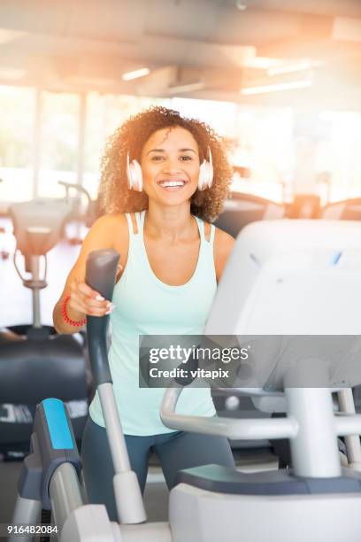 elliptical trainer cardio - happy caucasian woman on elliptical trainer at gym stock pictures, royalty-free photos & images