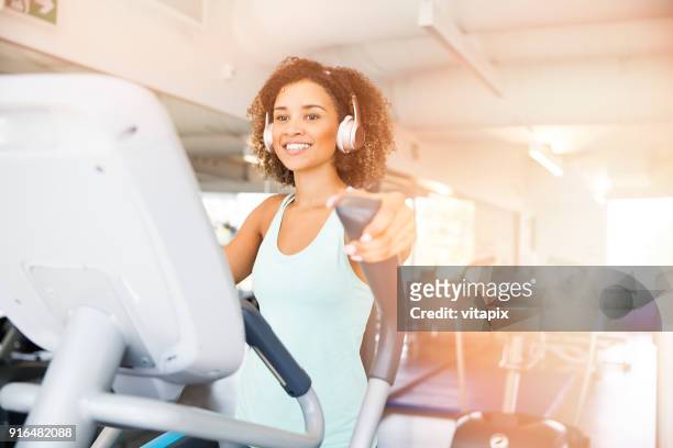 elliptical trainer cardio - happy caucasian woman on elliptical trainer at gym stock pictures, royalty-free photos & images