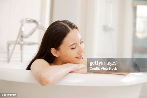 a fashionable young woman in the bathroom - sunken bath stock pictures, royalty-free photos & images