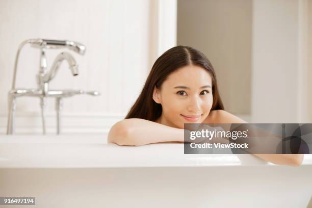 a fashionable young woman in the bathroom - sunken bath stock pictures, royalty-free photos & images