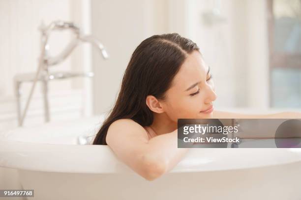 young women in the bathroom - sunken bath stock pictures, royalty-free photos & images