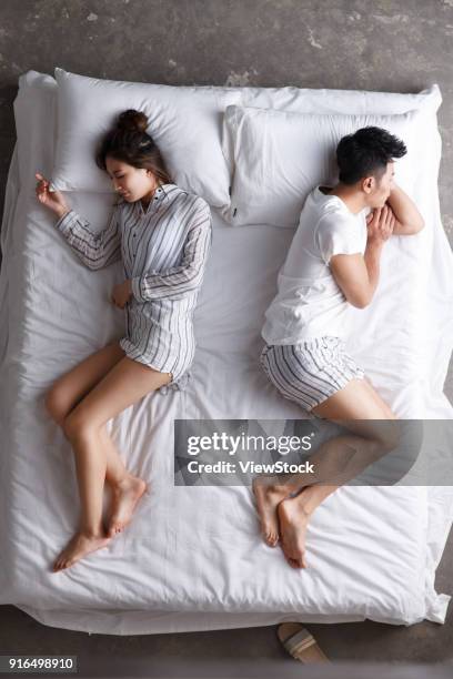 the young couple sleep in bed - côte à côte photos et images de collection