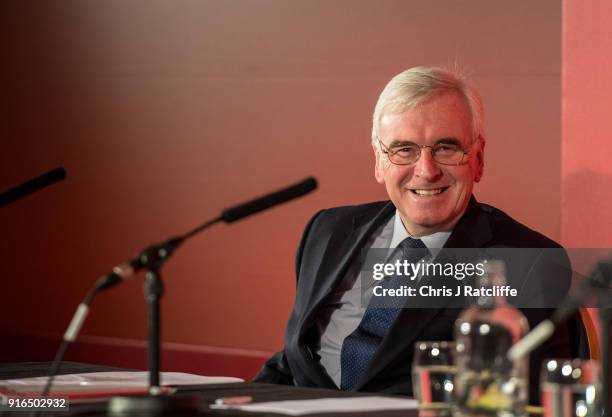 Shadow Chancellor John McDonnell sits on the panel before speaking at a Labour Party conference on alternative models of ownership on February 10,...