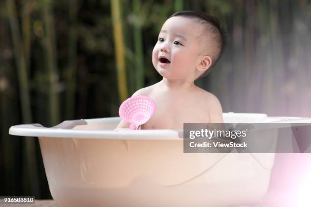 the lovely baby takes a bath - zinkwanne stock-fotos und bilder