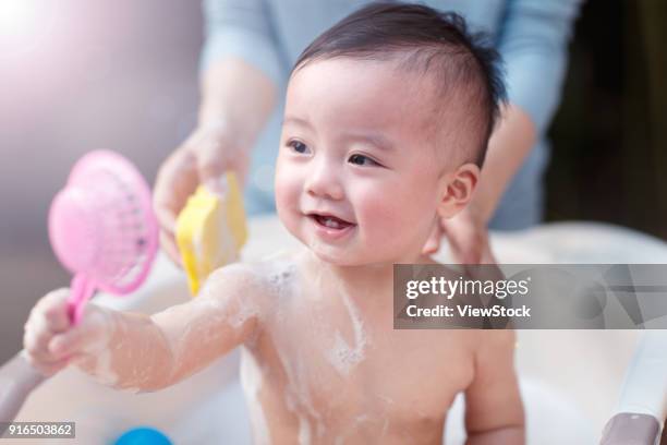 the lovely baby takes a bath - zinkwanne stock-fotos und bilder
