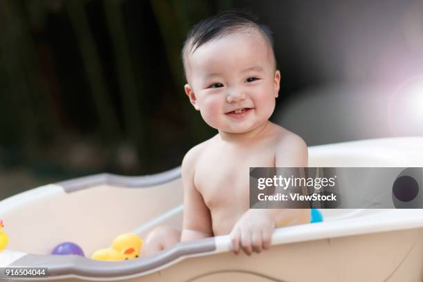the lovely baby takes a bath - zinkwanne stock-fotos und bilder