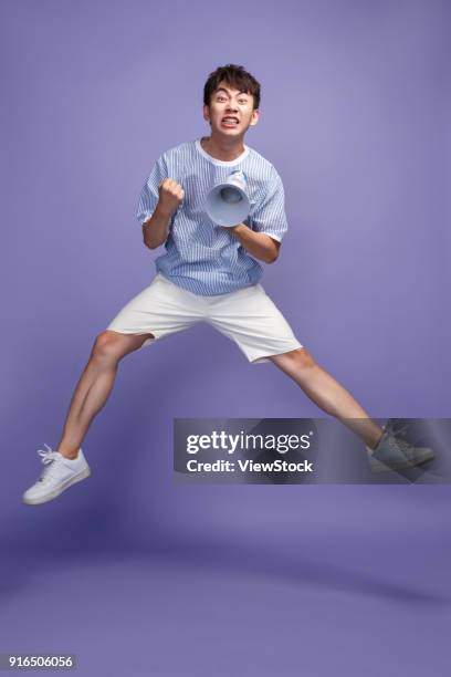 fashionable young man holding a microphone - legs apart imagens e fotografias de stock