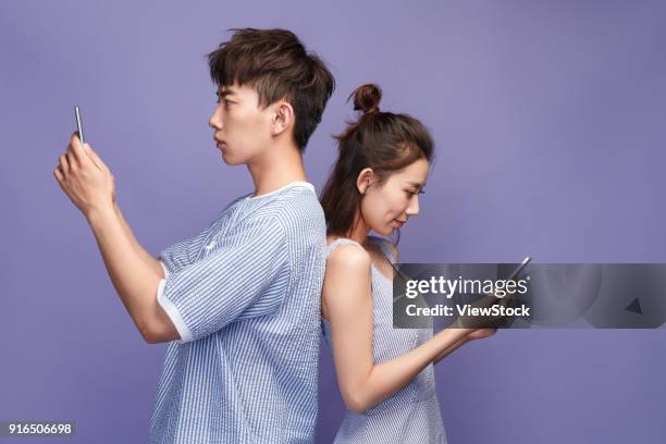 young couples playing mobile phone - disloyal boyfriend stock pictures, royalty-free photos & images