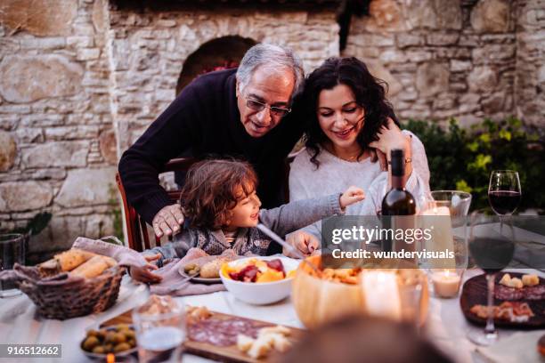 glückliche junge enkel dem mittagessen in großeltern landhaus - spain italy stock-fotos und bilder