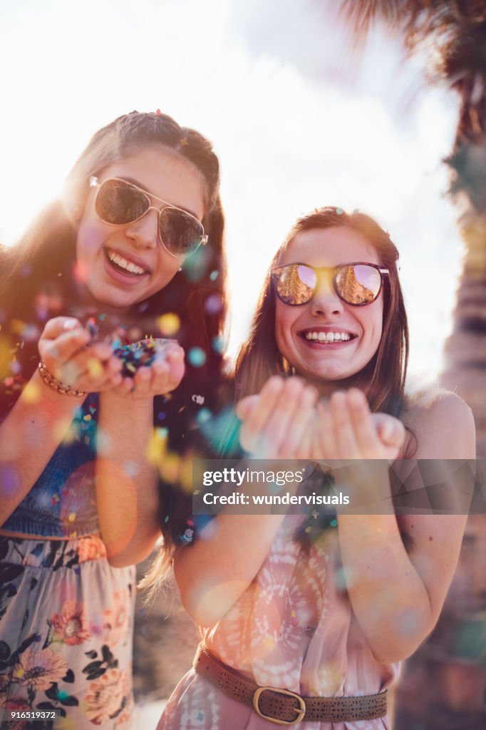 Young hipster women celebrating with confetti on summer holidays