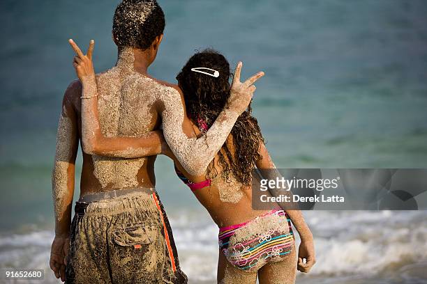 horizontal of young kids on beach doing peace sign - derek latta stock pictures, royalty-free photos & images