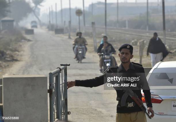 Pakistani policeman stands guard outside the check pint of Kot Lakhpat Jail where Mohammad Imran, the suspect accused of raping and murdering a young...