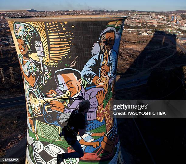 Man performs a bungee jump from the top of a thermal power planted, closed 11 years ago, in Soweto on June 28, 2009. The cooling tower is about 100m...