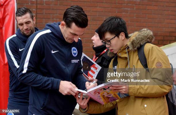 Lewis Dunk of Brighton and Hove Albion signs autographs as he arrives at the stadium prior to the Premier League match between Stoke City and...