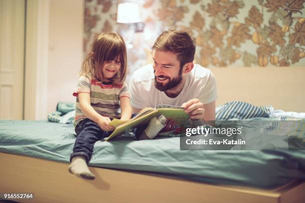 libro de lectura en su hogar - a boy jumping on a bed fotografías e imágenes de stock