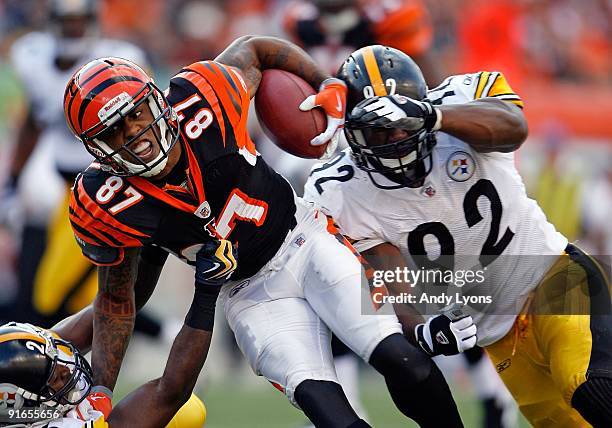 Andre Caldwell of the Cincinnati Bengals runs with the ball while defended by Deshea Townsend and James Harrison of the Pittsburgh Steelers at Paul...