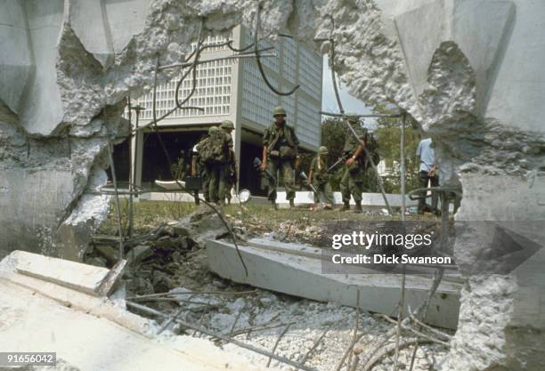View of US soldiers through a hole in the perimeter wall in the aftermath an attack on the US Embassy during the Tet Offensive, Saigon, Vietnam,...