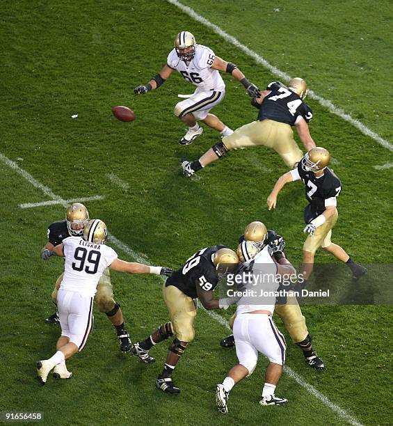 Jimmy Clausen of the Notre Dame Fighting Irish throws a pass out of the pocket as Daniel Te'O-Nesheim and Cameron Elisara of the Washington Huskies...