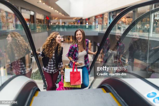 mädchen, die spaß im einkaufszentrum - shoppingcenter stock-fotos und bilder
