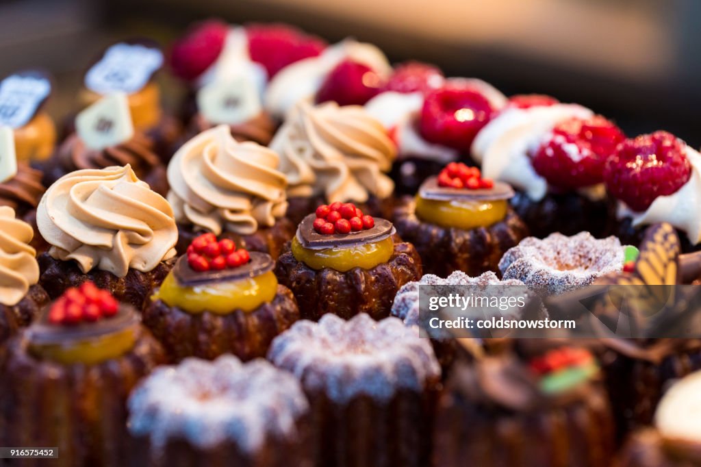 Close up of freshly baked cakes and cupcakes in a row at food market