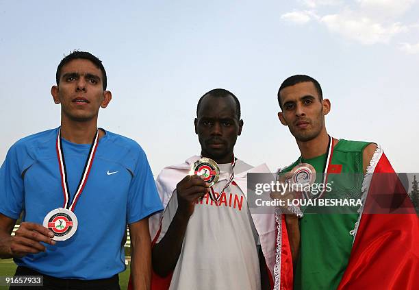 Men's 800m gold winner Bilal Mansur Ali of Bahrain poses on the podium with silver medallist Mohammed al-Azemi of Kuwait and bronze winner Mohsen...