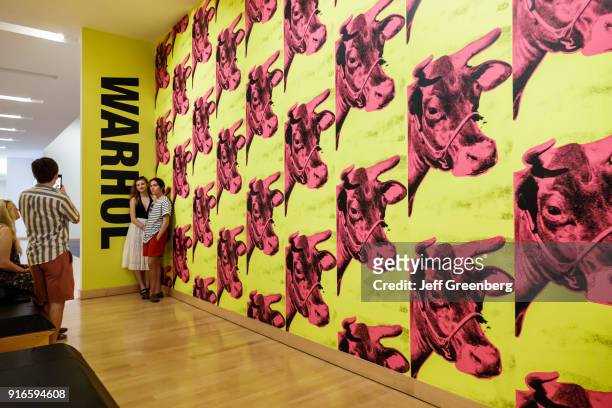 Two girls posing next to the Andy Warhol Pink Cows exhibit at the Boca Raton Museum of Art.
