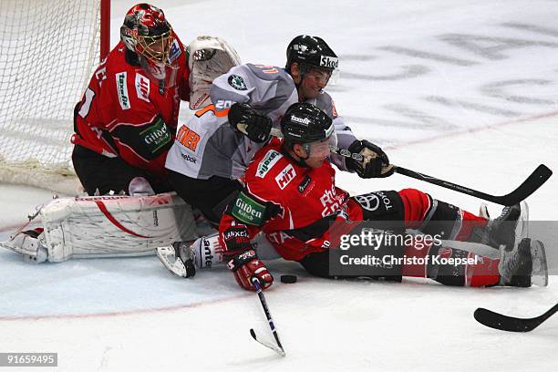 Christoph Hoehenleitner of Grizzly Adams EHC Wolfsburg pushes Mirko Luedemann of Koelner Haie and Lars Weibel of Koelner Haie during the DEL match...