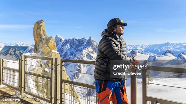 man standing at observation point contemplating mountains - aiguille de midi stock pictures, royalty-free photos & images