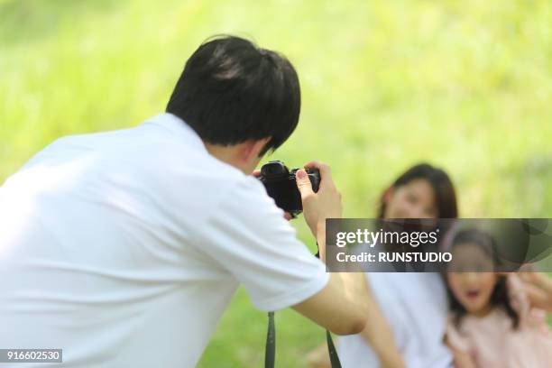 rear view of father taking picture of family - children camera stock pictures, royalty-free photos & images