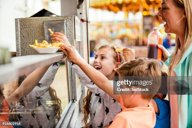 buying food at the fairground - concession stand fries stock pictures, royalty-free photos & images