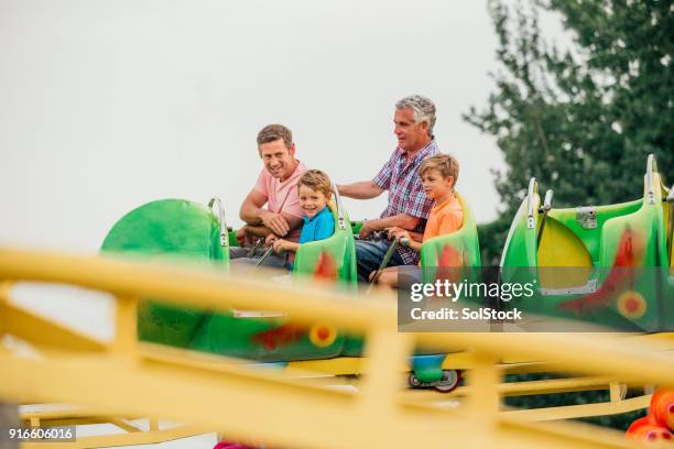 multi-generation males on a fairground ride - fairground stock pictures, royalty-free photos & images