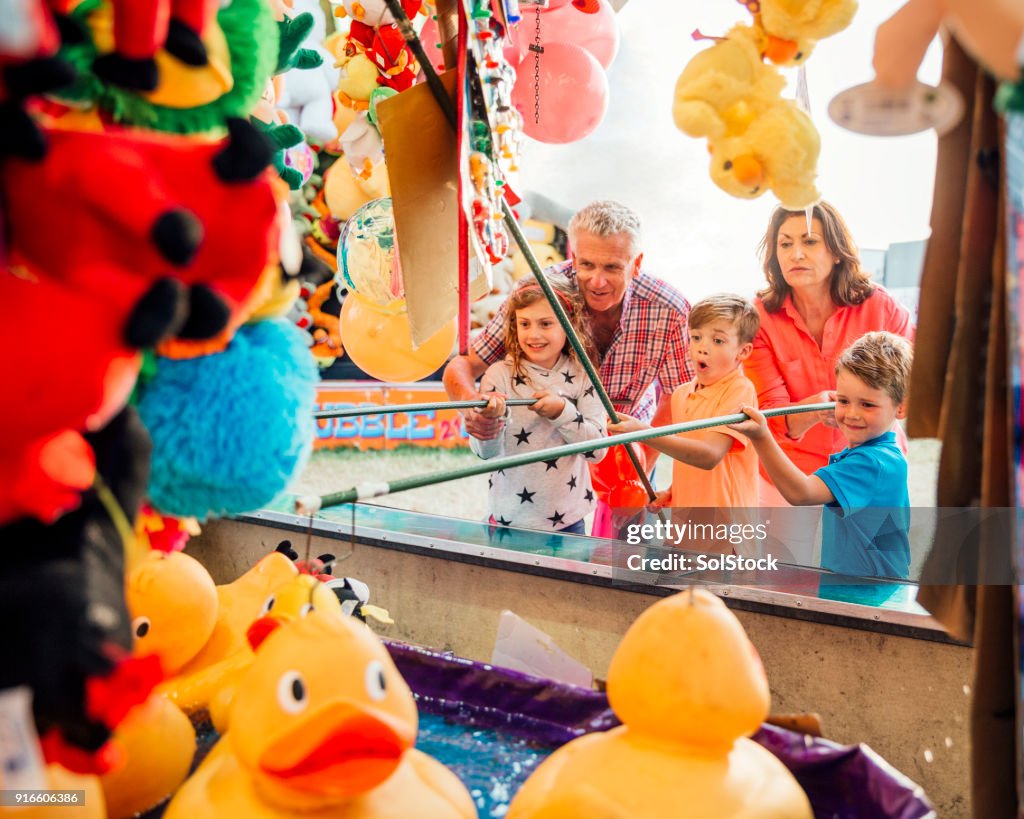 Grandparents Help their Grandchildren Hook a Duck