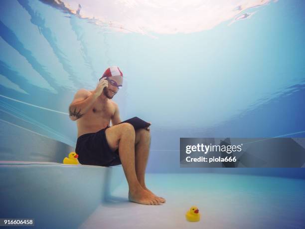 uomo che lavora al telefono sott'acqua - crazy pool foto e immagini stock