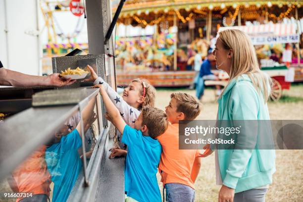 familie, essen auf dem messegelände - wohltätigkeitsfest stock-fotos und bilder