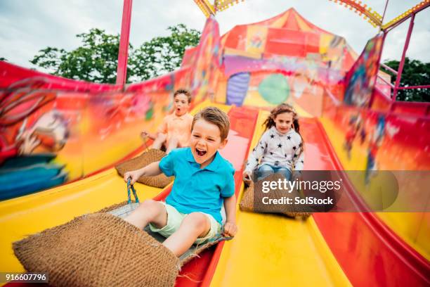 kinderen op de eerste dia op een kermis - glijden stockfoto's en -beelden