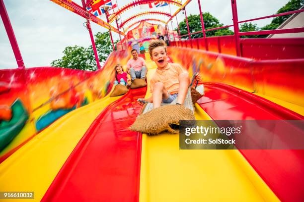 little boy on slide at a funfair - slide stock pictures, royalty-free photos & images