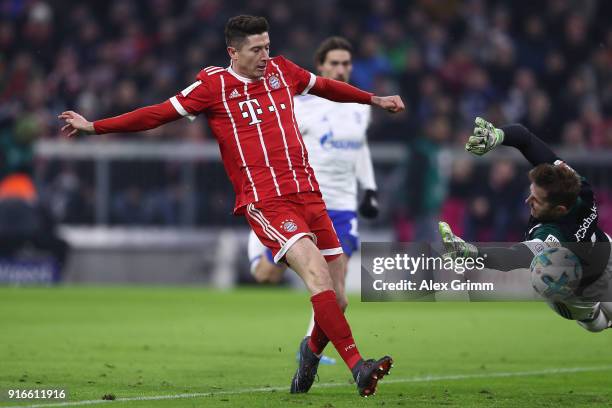 Robert Lewandowski of Bayern Muenchen scores a goal past goalkeeper Ralf Faehrmann of Schalke to make it 1:0 during the Bundesliga match between FC...
